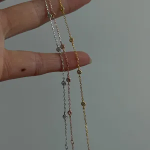 Primo piano di tre delicati bracciali in argento s925 in oro, argento e oro rosa.