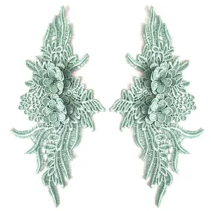 Detailed mint green symmetrical lace patches featuring heavy 3D floral embroidery.