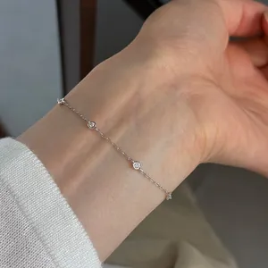 Primo piano di un delicato bracciale a catena in argento S925 con mini zirconi sul polso