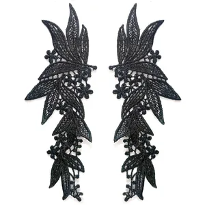 Detailed view of symmetrical black polyester lace floral embroidery appliques.