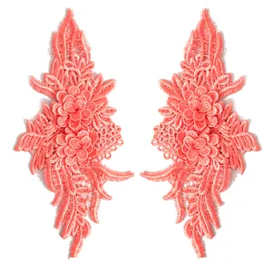 Detailed macro view of symmetrical coral lace floral embroidery appliques for DIY crafts.