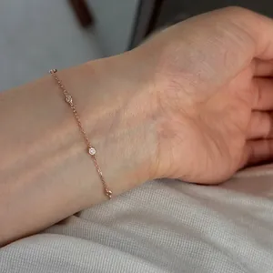 Primo piano di un sottile braccialetto minimalista in argento s925 con diamanti sul polso