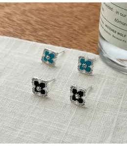 Detail of S925 silver clover stud earrings with turquoise and black agate gems.