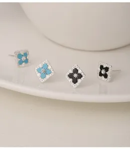 Elegant S925 silver clover stud earrings with black onyx and turquoise inlays and CZ borders.