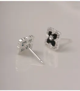 Detailed macro view of S925 silver stud earrings with hallmark and mixed gemstone inlays