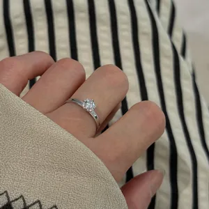 Close-up detail of S925 sterling silver ring with brilliant-cut stone worn on a finger