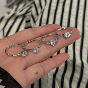 Detailed view of four S925 silver rings with heart and round cut stones shown on hand