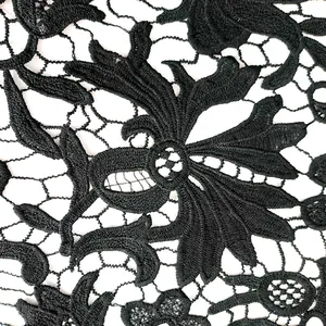 Macro di intricato ricamo floreale nero traforato su tessuto di pizzo idrosolubile