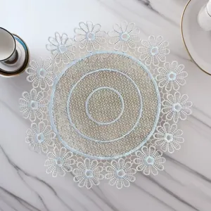 Detailed view of a light blue round embroidered lace placemat with floral edges.