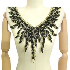 Gros plan d'un col en dentelle brodée noir et or sur un mannequin détail