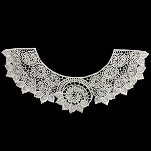 Close-up of a white hollow embroidered lace collar with intricate floral pattern.