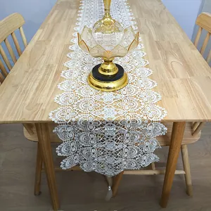 Detailed view of a white hollow-out lace table runner with 3D floral embroidery patterns