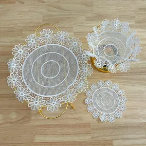 Elegant white lace floral embroidery placemats and doilies set on wooden surface