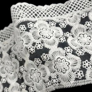 Detailed macro shot of white milk silk floral embroidery on black mesh background