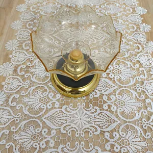 Detailed macro view of white water-soluble lace table runner with 3D floral embroidery