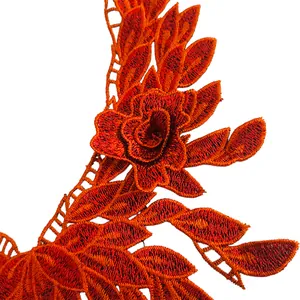 Gros plan d'un col en dentelle brodée orange vif avec des détails de broderie fine