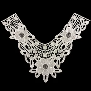 Detailed macro view of intricate white floral embroidery on a water-soluble lace collar