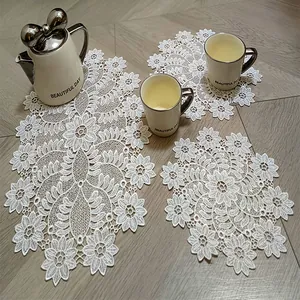 Elegant set of white hollow lace embroidered placemats shown with a vintage tea set
