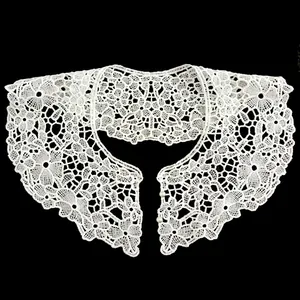 Macro view showing the intricate floral embroidery and pearl buttons on a white lace collar.