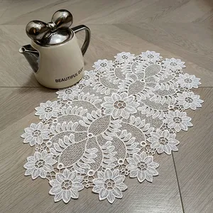 Close-up detail showing the intricate floral embroidery on this white lace placemat