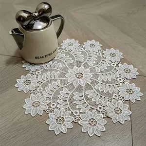 Close-up of intricate floral lace embroidered doily used as a decorative coaster