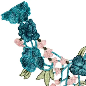 Detaillierte Nahaufnahme von kunstvoller ethnischer Blumenstickerei mit blaurosa Blüten