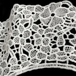 Close-up of white milk silk embroidered lace with intricate floral hollow design.