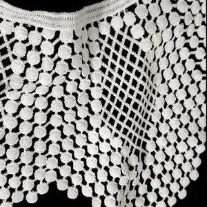 Close-up macro view of delicate white milk silk embroidered lace with dot patterns