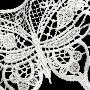 Detailed macro view of white polyester embroidered lace collar with floral pattern