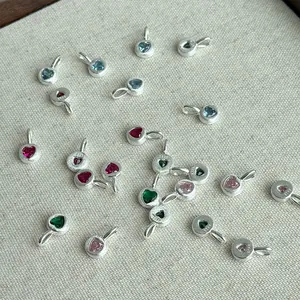 Detailed macro view of S925 sterling silver heart-shaped pendants with colorful stones