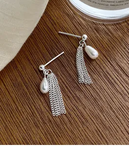 Vue détaillée de boucles d'oreilles en argent S925 avec perles et pompons de chaîne.