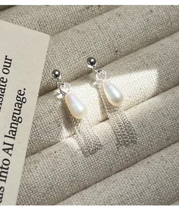 Détail de boucles d'oreilles élégantes en argent S925 avec perles gouttes et franges