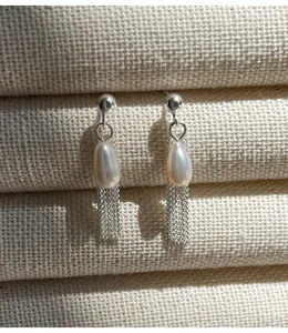 Gros plan sur des boucles d'oreilles s925 avec perles naturelles et franges fines