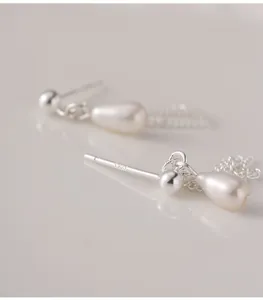 Gros plan de boucles d'oreilles en argent S925 avec perles naturelles et chaînes