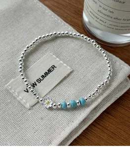 Détail du bracelet en argent sterling avec breloque marguerite et perles de turquoise