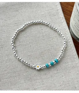 Vue détaillée d'un bracelet en argent 925 avec breloque marguerite et perles turquoise