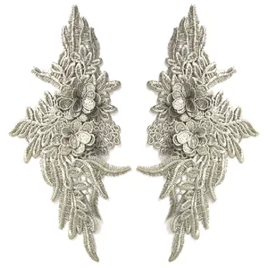 Macro view of elegant silver lace flower appliqués with heavy embroidery stitch detail