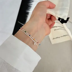 Detail of layered s925 silver bracelet with colorful beads and silver ball pendant