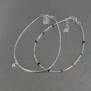 Detail view of S925 silver stackable bracelets with colorful beads and heart charm