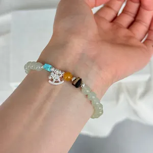 Detailansicht eines 925er Silber Schaukelpferd Armbands mit Jade- und Bernsteinperlen