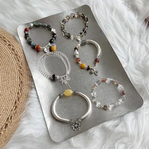 Colección de seis pulseras artesanales de plata S925 y cristales naturales en bandeja.
