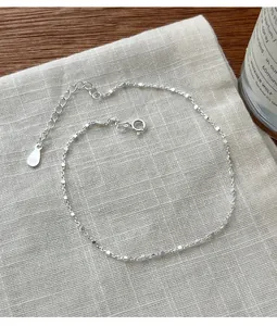 Detail einer 925 Sterling Silber Fußkette mit feiner quadratischer Perlenkette