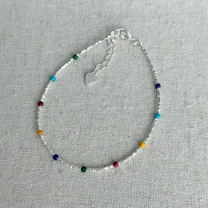 Close-up view of a s925 silver bracelet featuring vibrant colorful beads and a heart charm
