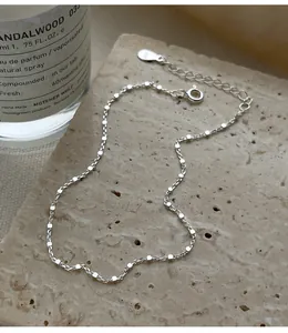 Detailaufnahme einer minimalistischen Fußkette aus 925er Sterlingsilber auf Naturstein.