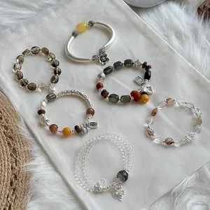 Colección de pulseras de plata S925 y cristales naturales sobre fondo de tela blanca