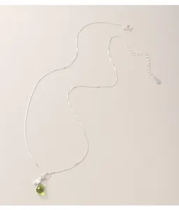 Detailed view of s925 sterling silver necklace featuring a star and green glass teardrop