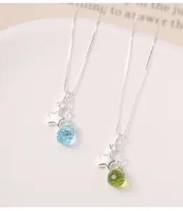Close-up of s925 silver star and faceted teardrop glass pendants on a box chain.