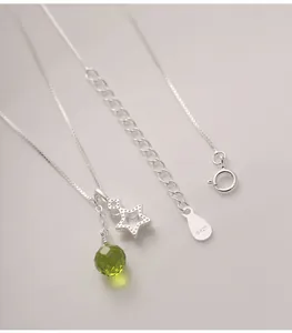 Detailed shot of S925 silver star necklace with faceted green glass drop pendant