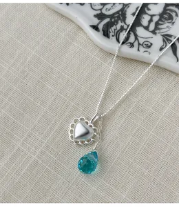 Elegant S925 silver heart and blue waterdrop pendant necklace on premium linen background