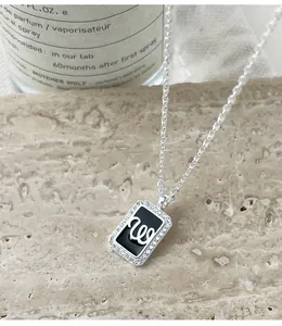 Close-up of S925 silver square pendant necklace with W initial and crystal border.